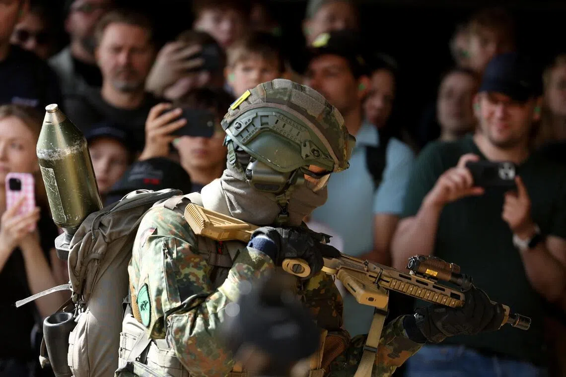 Visitors watch as an armed soldier conducts a demonstration during the "Tag der Bundeswehr", as the German armed forces Bundeswehr open their doors to the public, in Unna, Germany, June 6, 2026. REUTERS/Leon Kuegeler