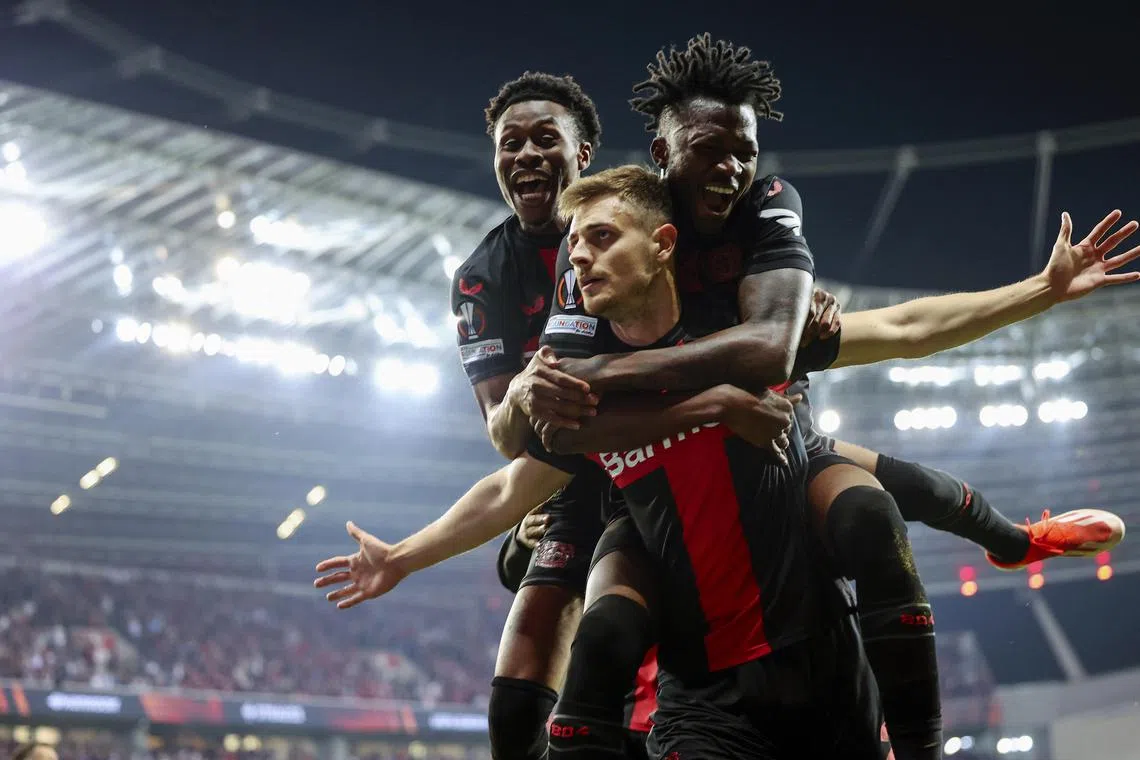 Josip Stanisic (centre) celebrating with Leverkusen teammates after equalising at 2-2 in the Europa League semi-final second leg against Roma in Germany on May 9, 2024. 