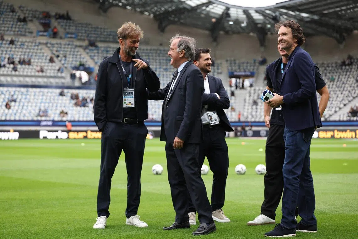 Global head of football at Red Bull Jurgen Klopp speaks with Paris FC's French president Pierre Ferracci.