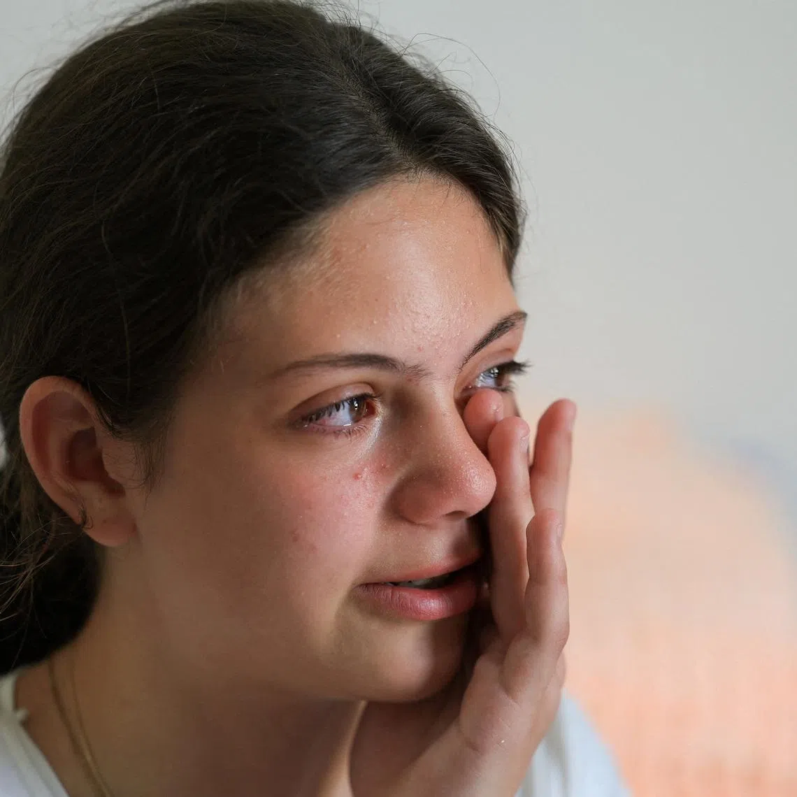 FILE PHOTO: Salma Safadi, 13, a Christian girl displaced from Tyre, southern Lebanon, reacts during an interview with journalists as she sits in her family's room where they take refuge at the House of Saint Anne for Youth, overseen by the Greek Melkite Catholic Patriarchate, in Rabweh, Lebanon, June 10, 2026. REUTERS/Mohamed Azakir/File Photo