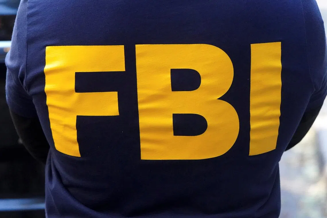 An FBI logo is pictured on an agent's shirt during the U.S. law enforcements raid on Russian oligarch Oleg Deripaska's property in the Manhattan borough of New York City, New York, U.S. October 19, 2021.  REUTERS/Carlo Allegri/File Photo