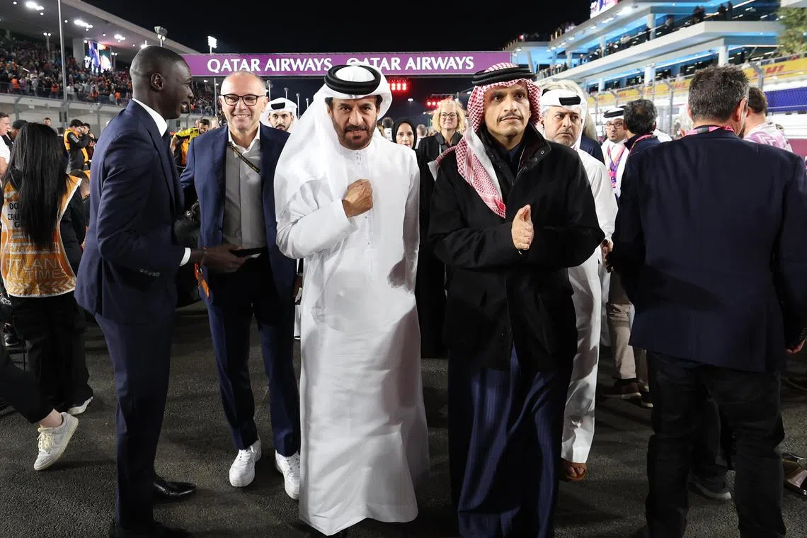 Qatar Prime Minister Mohammed bin Abdulrahman bin Jassim Al Thani (centre, right) and FIA president Mohammed Ben Sulayem walk on the starting grid before the Qatar Grand Prix.
