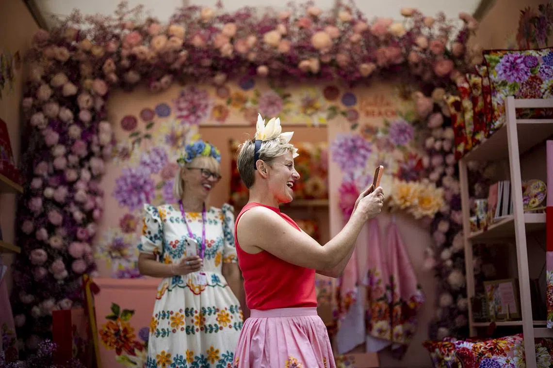 epa10645977 Visitors react as they take pictures of flower installations during the Chelsea Flower Show in London, Britain, 22 May 2023. The annual gardening exhibition runs from 23 to 27 May 2023 at the Royal Chelsea Hospital in London. EPA-EFE/TOLGA AKMEN