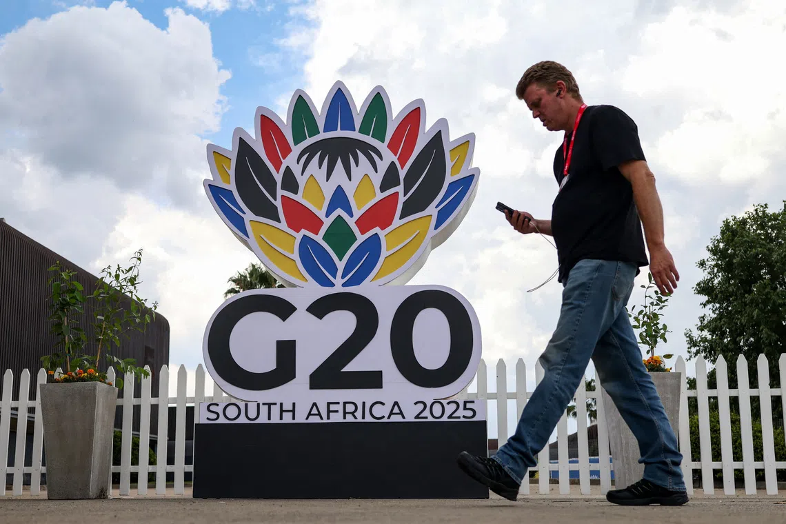 A man walks past a G20 South Africa 2025 sign inside the secured area of the G20 Summit venue at the Nasrec Expo centre, ahead of the summit scheduled for November 22–23 in Johannesburg, South Africa. November 21, 2025. REUTERS/Siphiwe Sibeko