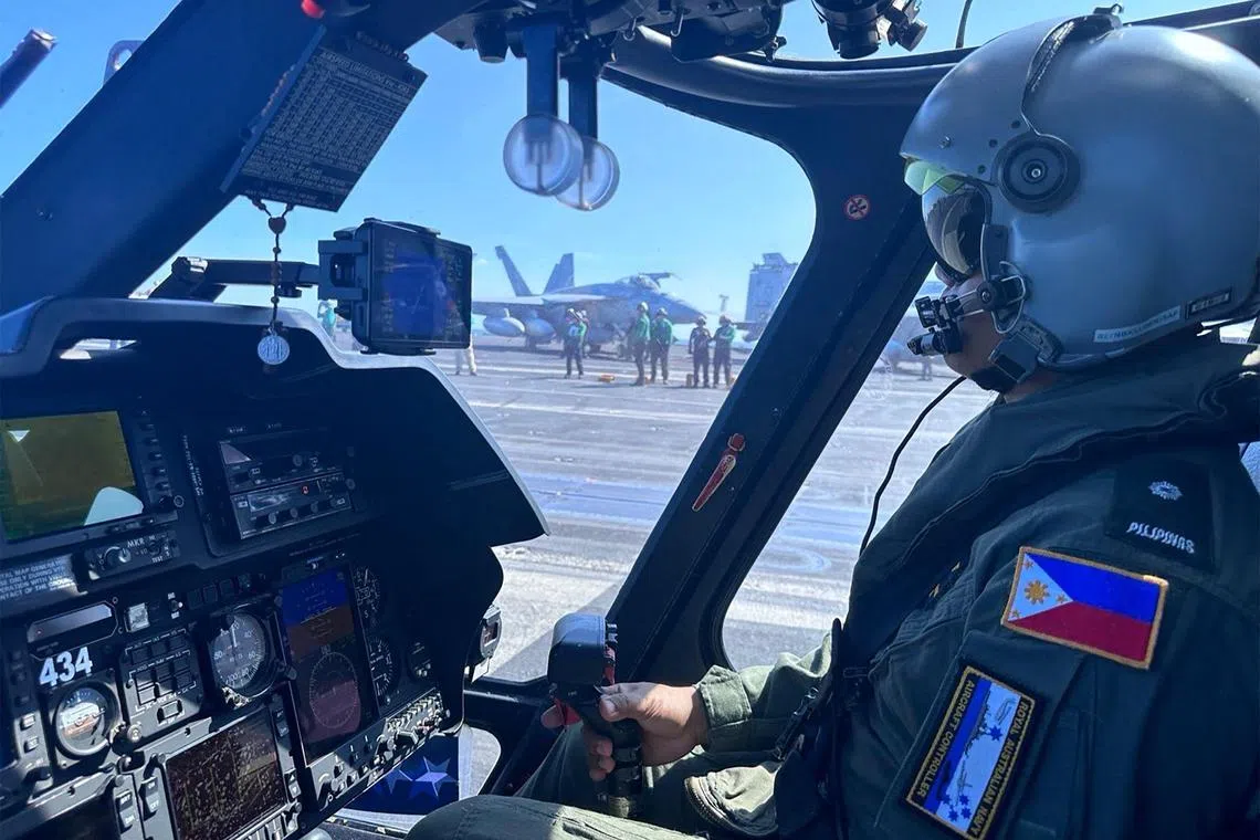 A pilot executes a final check in a Philippine Navy helicopter, on the deck of the USS Carl Vinson, during a joint exercise with the United States.