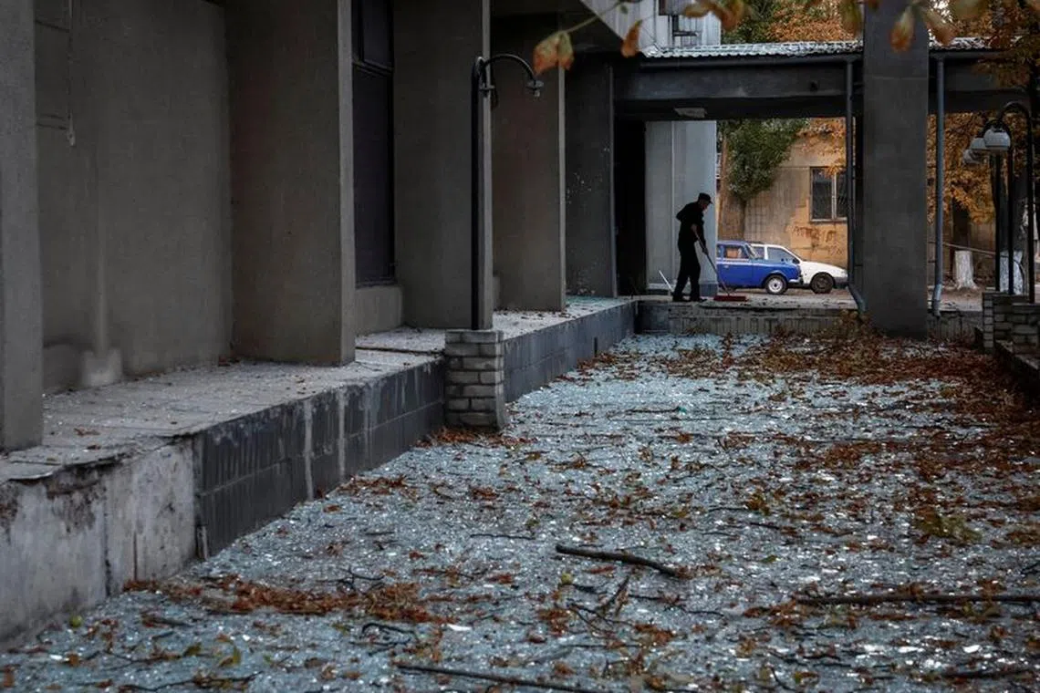 FILE PHOTO: A staff cleans up broken windows of a building damaged during a Russian drone strike, amid Russia's attack on Ukraine, in Kyiv, Ukraine September 10, 2023. REUTERS/Gleb Garanich
