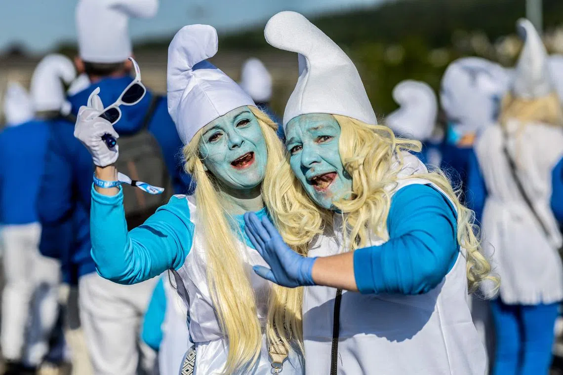 Participants wearing smurf (schtroumpf) costumes take part in an attempt to break the world record for the largest gathering of Smurfs, in Landerneau, western France, on May 17, 2025. Landerneau on May 17 attempts to break the world record for the largest Smurfs gathering, a record held by Lauchringen in Germany, after two failed attempts over five years. (Photo by Fred TANNEAU / AFP)