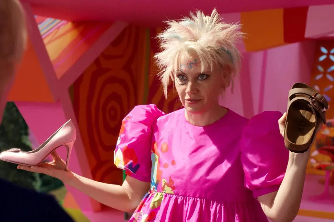 Actress Kate McKinnon, who plays Weird Barbie, holds a Birkenstock sandal (right), in the movie Barbie.