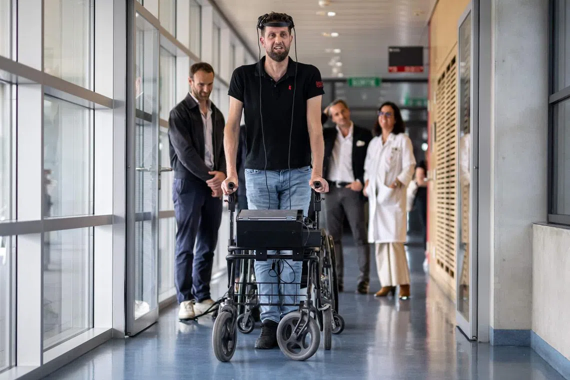 Gert-Jan from the Netherlands, (who did not wish to give his surname), 40, victim of a spinal cord injury that left him paralyzed, poses with his implants that allows him to walk naturally, during a press conference in Lausanne on May 23, 2023. For the first time after more than a decade of work by researchers in France and Switzerland, a paralysed man has regained the ability to walk naturally using only his thoughts thanks to two implants that restored communication between his brain and spinal cord. The advance was revealed in a study in the journal Nature. (Photo by Fabrice COFFRINI / AFP)