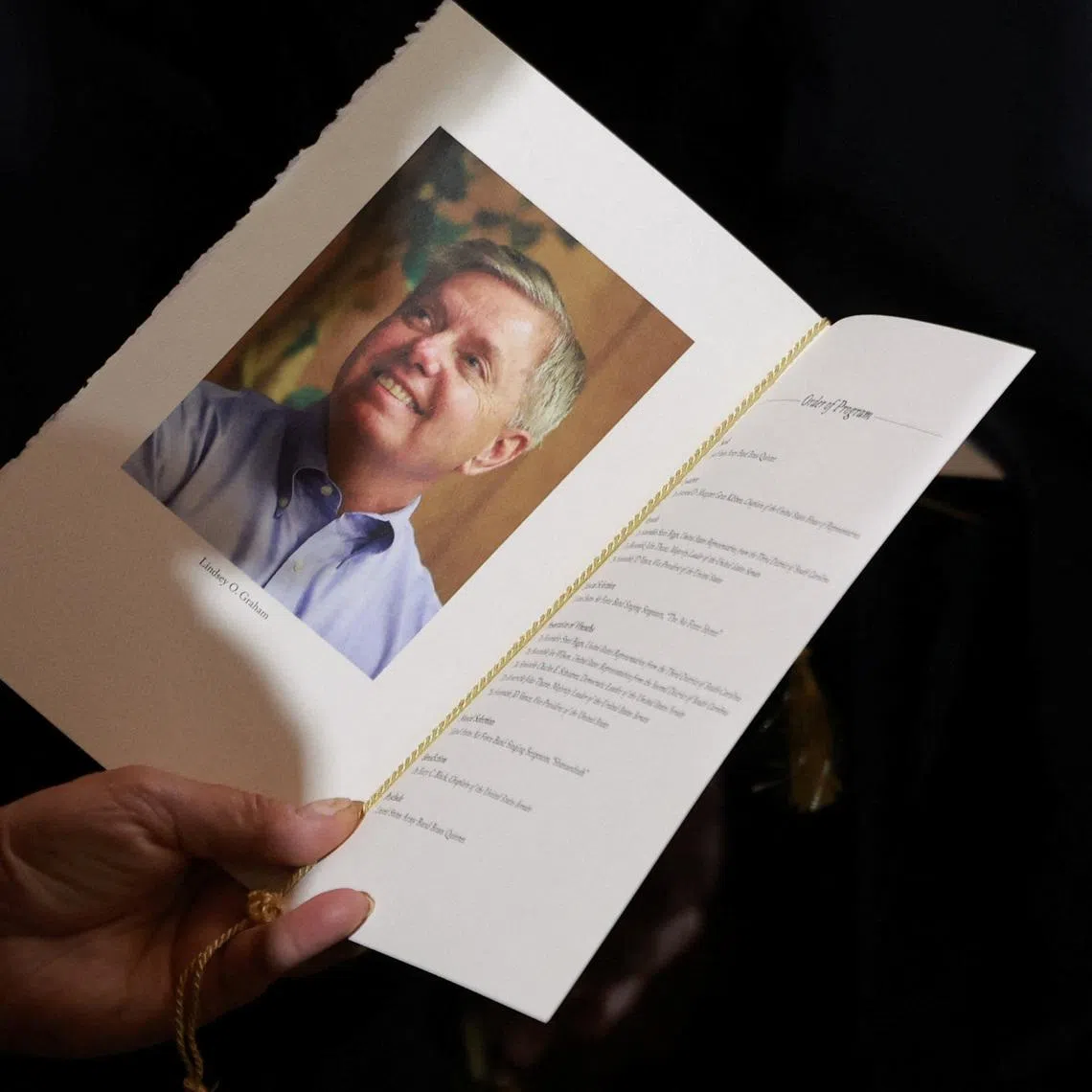 An attendee holds a program during a ceremony for late Republican Senator Lindsey Graham (R-SC) in the rotunda of the US Capitol in Washington, DC, US, on Tuesday, July 28, 2026. Tierney L. Cross/Pool via REUTERS