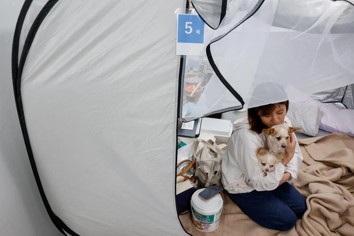 Tomoko Takaoka, 31, evacuated with her pet dogs to an evacuation centre to escape the heat.