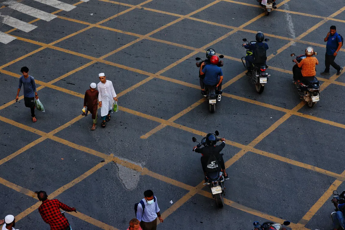 Pedestrians cross a road in the Karwan Bazar area, Dhaka, Bangladesh, July 17, 2025. REUTERS/Mohammad Ponir Hossain