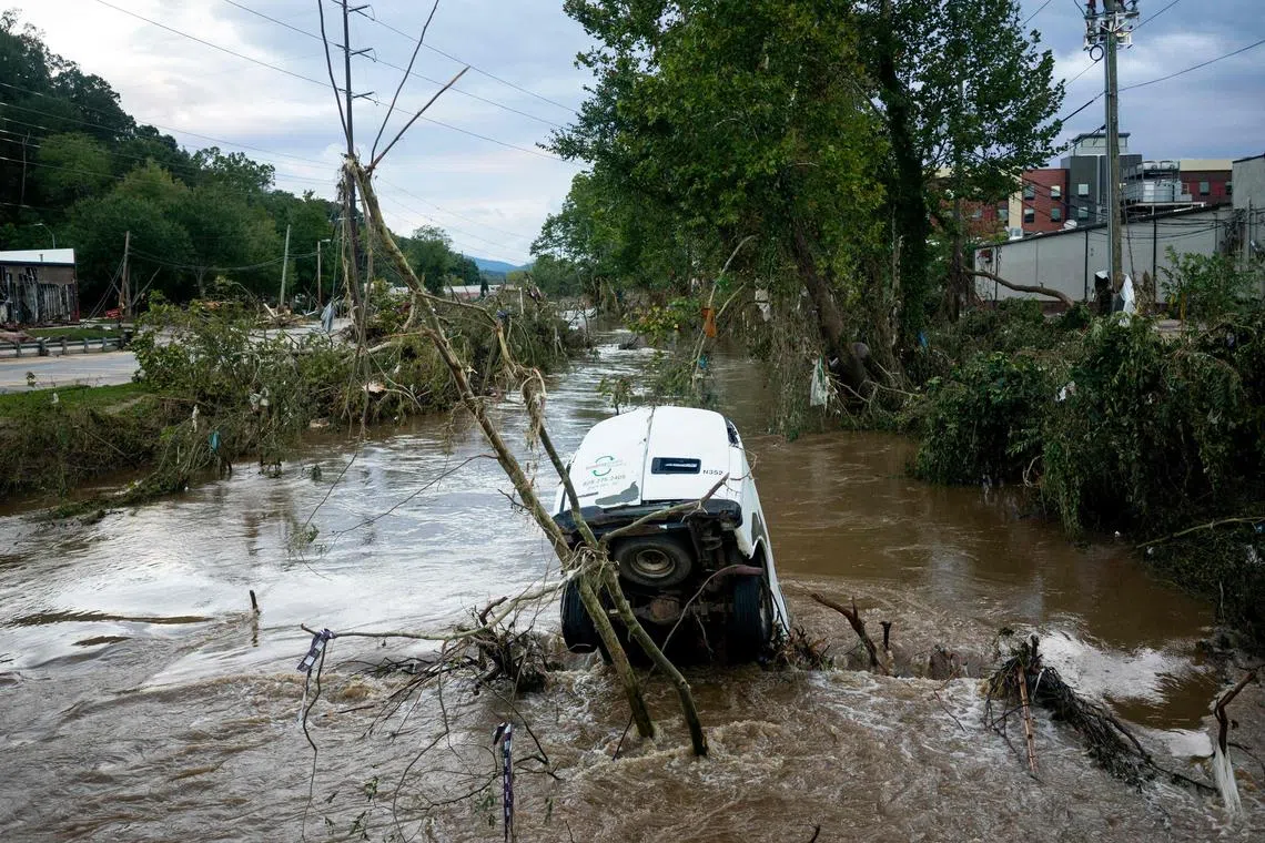 A van is partially submerged in the Swannanoa River in the Biltmore Village in the aftermath of Hurricane Helene on Sept 29 in Asheville, North Carolina. 