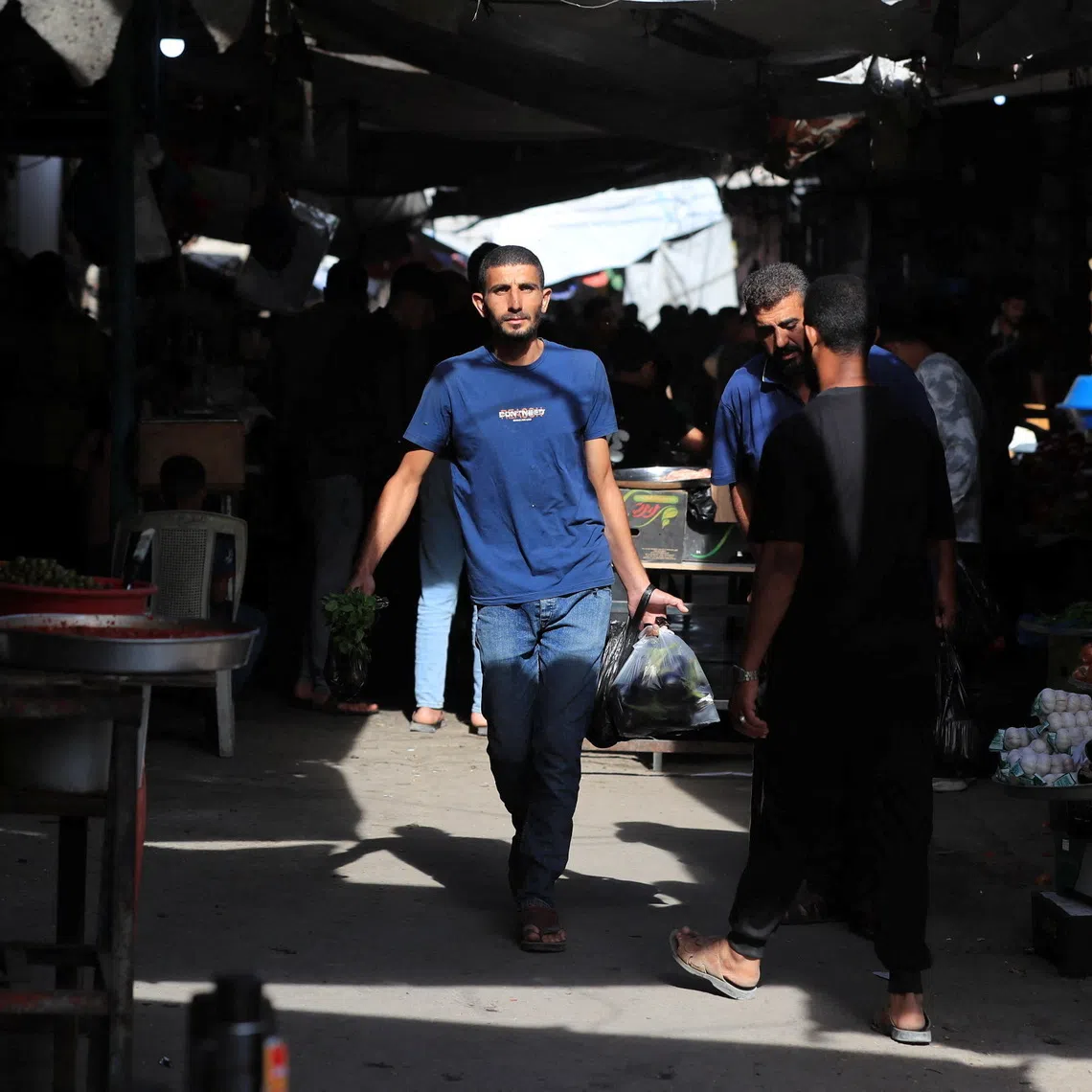 Palestinians walk through a street market in Gaza City, October 16, 2026. REUTERS/Dawoud Abu Alkas