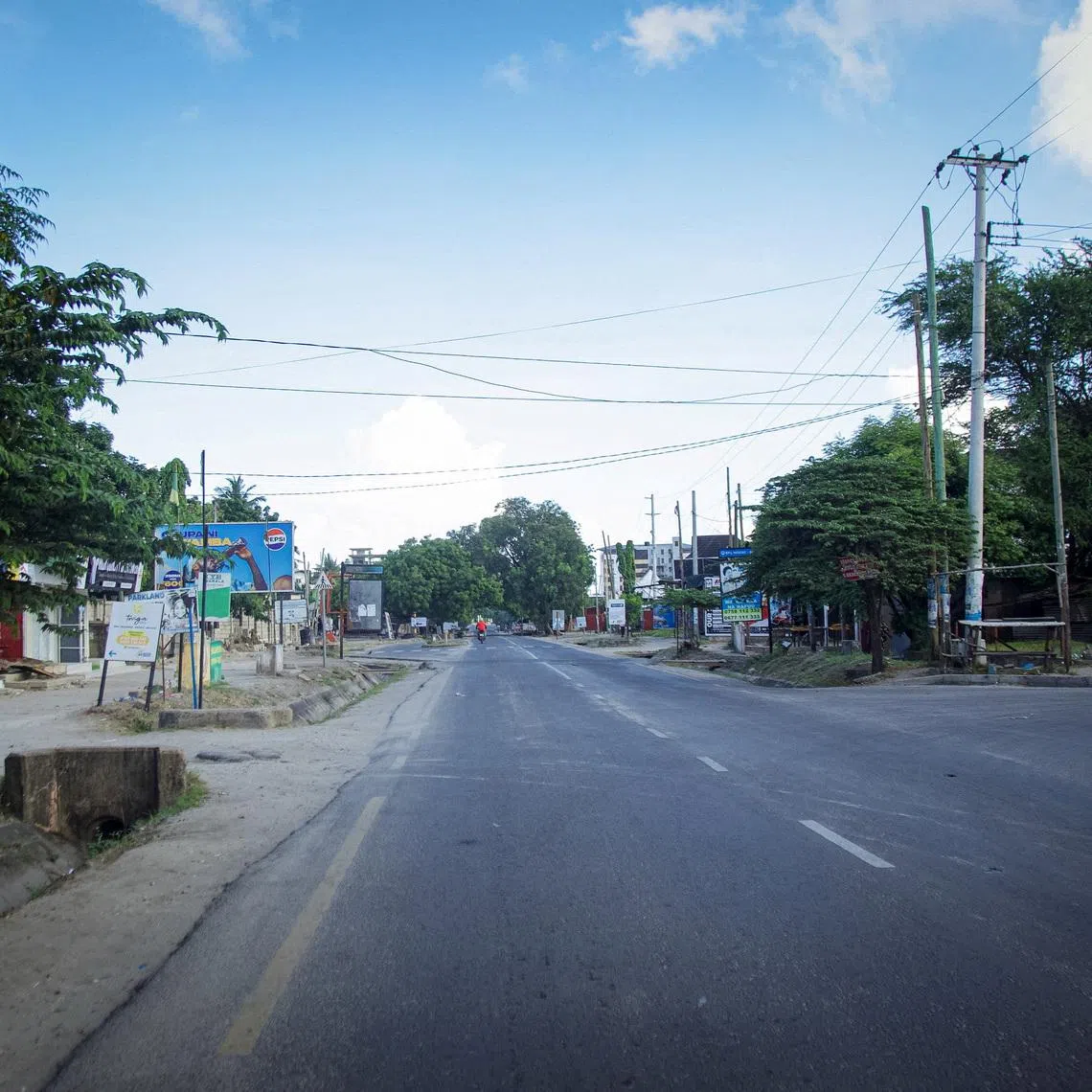 A motorcyclist rides on a deserted street during the 64th Independence Day under a lockdown imposed by the government to counter planned anti-government protests against deadly violence during demonstrations around the October elections, in Dar es Salaam, Tanzania, December 9, 2025. REUTERS/Emmanuel Herman