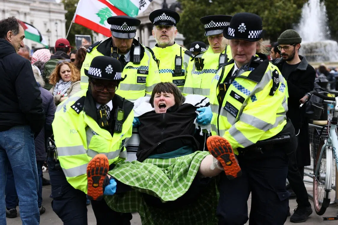 A protester being carried away by police in Trafalgar Square, central London, on Oct 4.