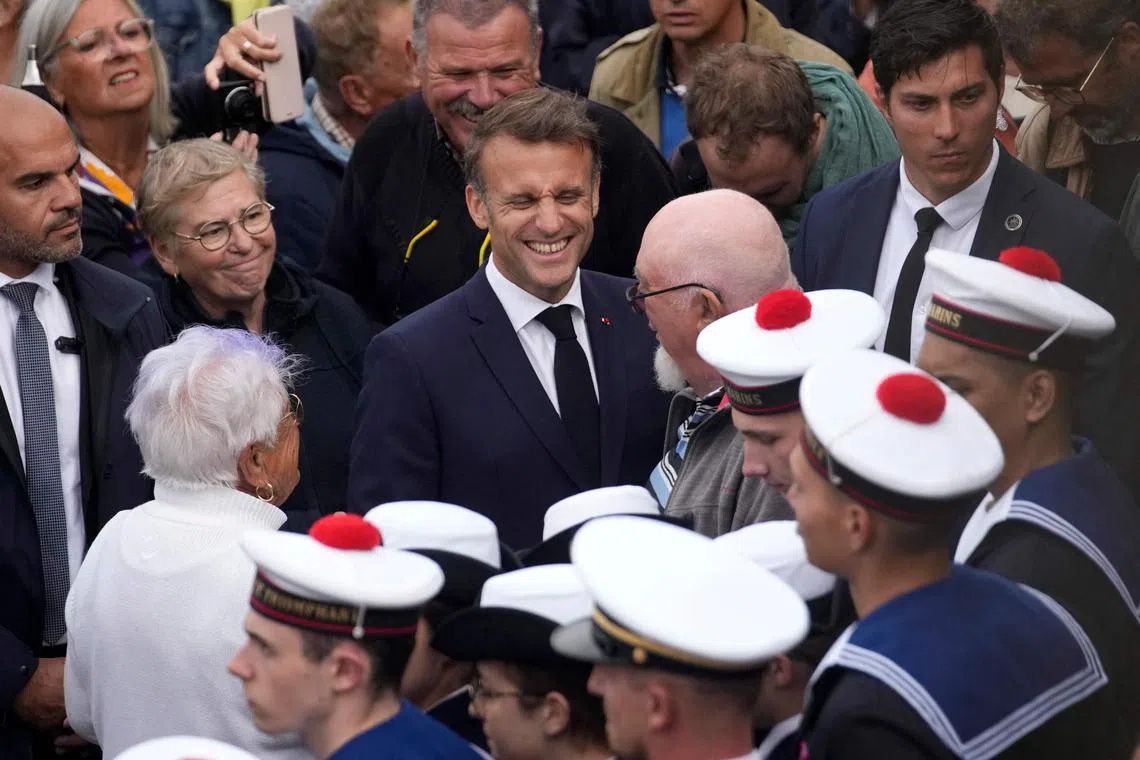 French President Emmanuel Macron (centre) speaking with residents and French navy personnel, at a World War II event in Brittany, on June 18.