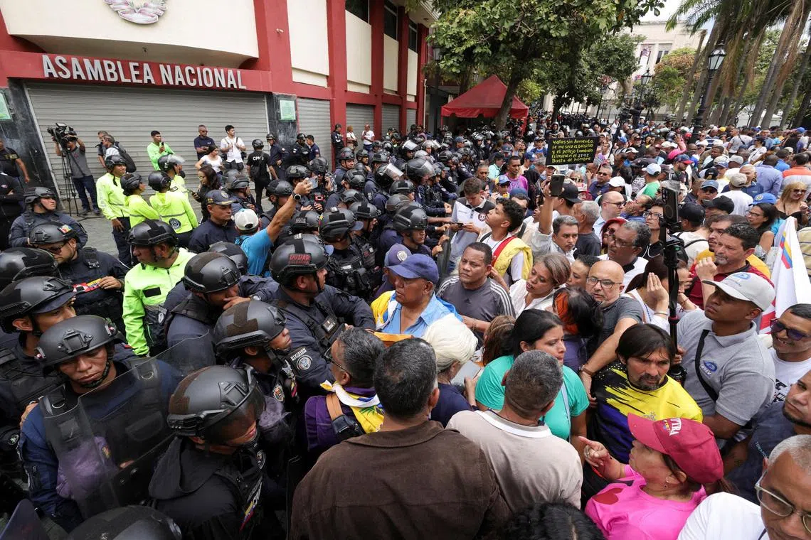 Protesters rally outside the National Assembly demanding higher wages, improved pensions, restored labor rights and the release of detainees in Caracas, Venezuela, March 12, 2026. REUTERS/Gaby Oraa