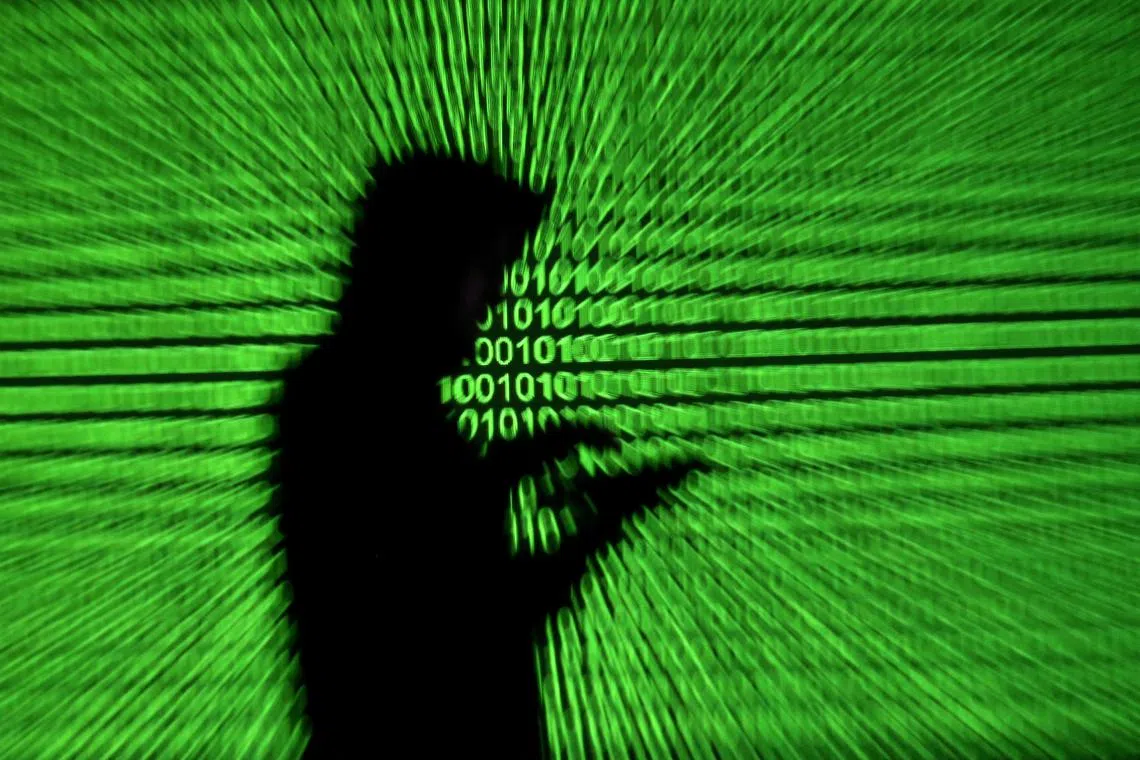 FILE PHOTO: Silhouette of mobile device user is seen next to a screen projection of binary code are seen in this picture illustration taken March 28, 2018.  REUTERS/Dado Ruvic/Illustration/File Photo