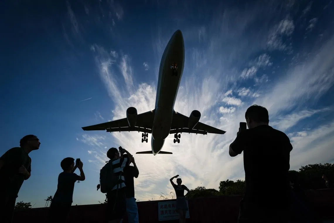 People observing an approaching China airlines flight in Taipei, Taiwan, on May 15, 2024. 