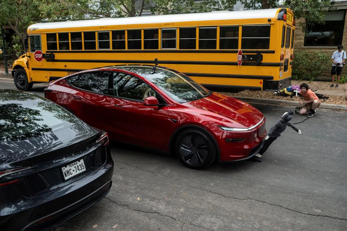 FILE PHOTO: Arthur Maltin, a test driver with The Dawn Project, hits a crash dummy as it crosses the road during a safety test on a Tesla Model Y’s self-driving feature at a protest against Tesla robotaxis, ahead of the Tesla robotaxis' official services in Austin, Texas, U.S., June 12, 2025.    REUTERS/Joel Angel Juarez/File Photo