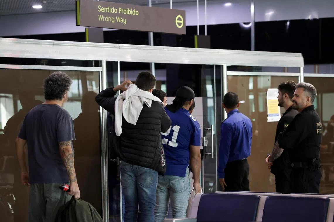 Brazilian migrants deported from the US under President Donald Trump's administration, walk as they board a Brazilian Air Force flight to Brazil.
 
