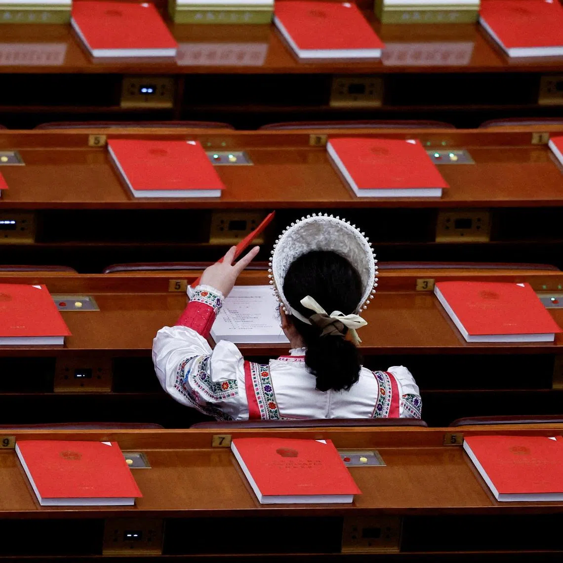 FILE PHOTO: A delegate in an ethnic minority costume arrives before the closing session of the National People's Congress at the Great Hall of the People in Beijing, China March 12, 2026. REUTERS/Tingshu Wang/File Photo