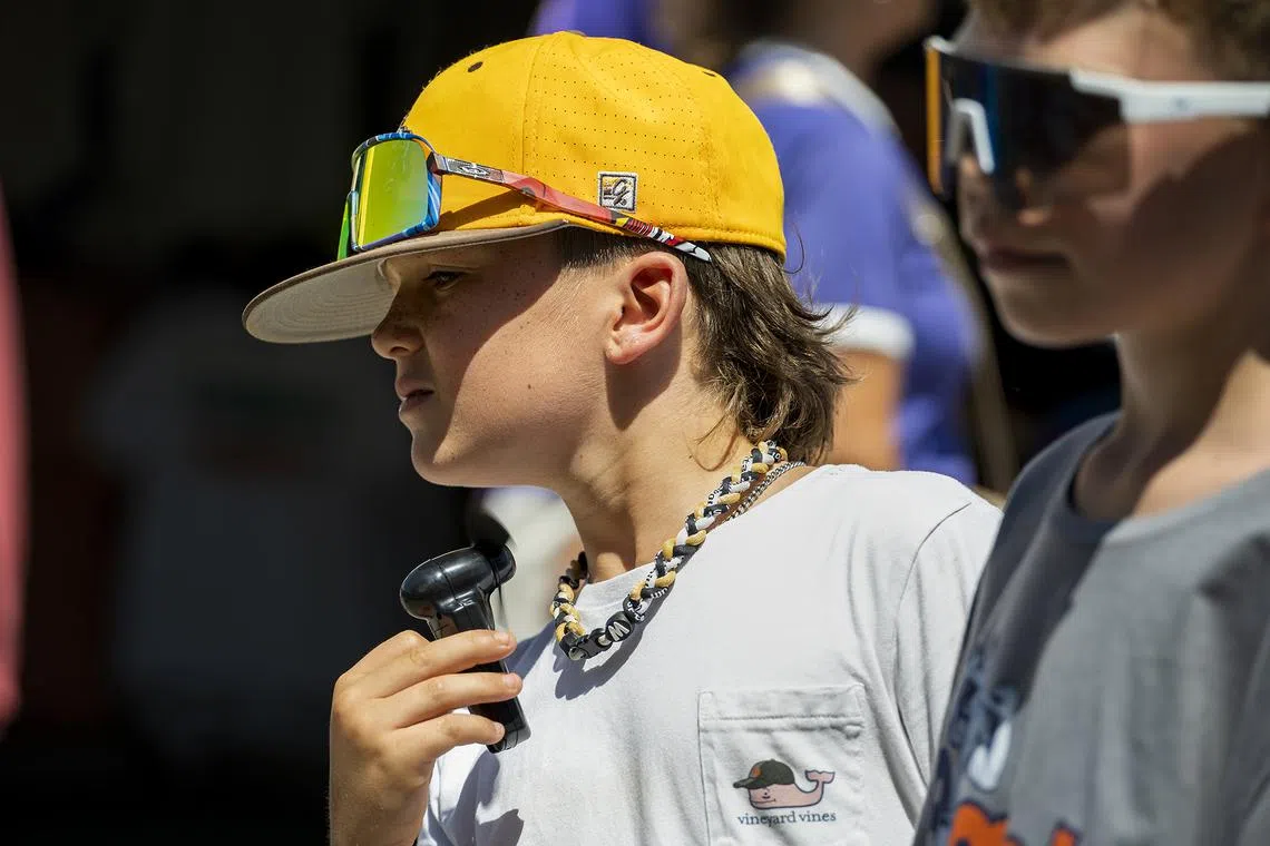 A College World Series attendee cools off with a fan in Omaha, Nebraska, on June 21, 2025. 