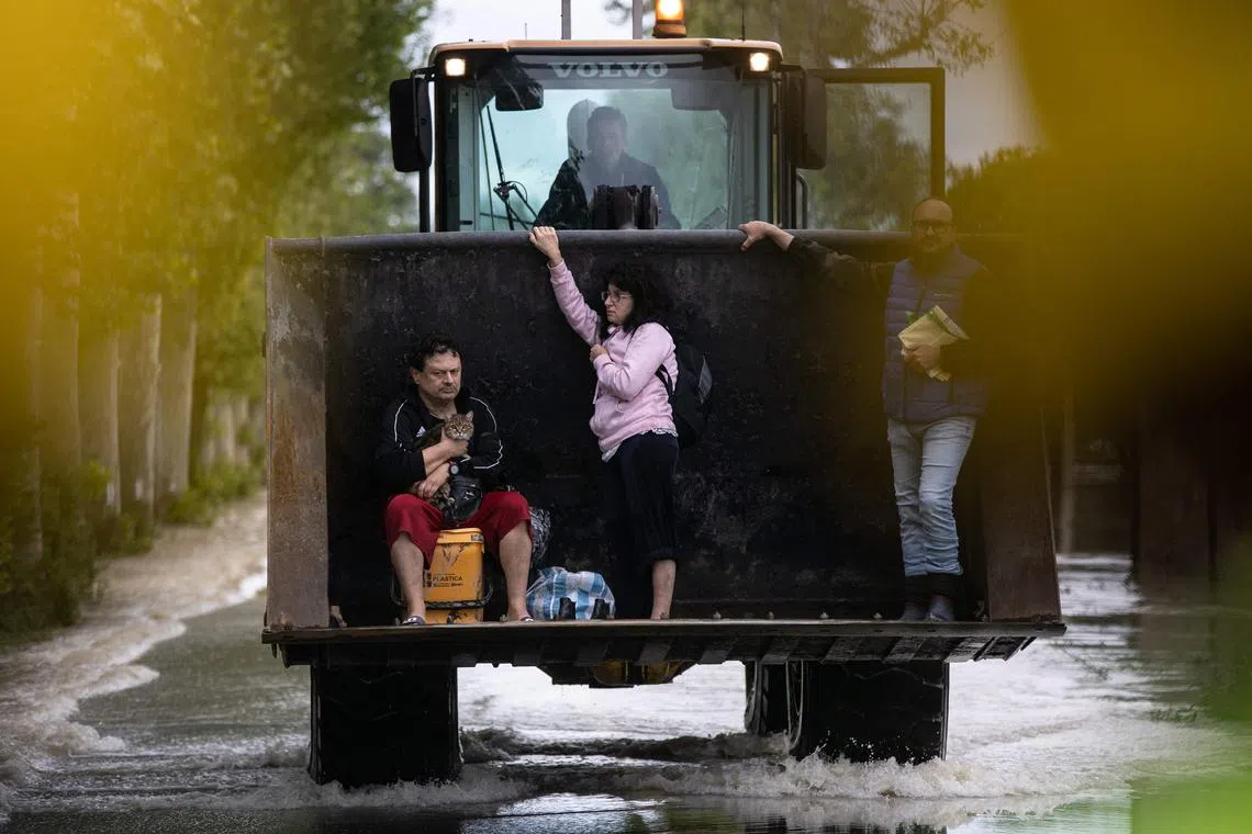 Residents are rescued on a digger on May 17, 2023, in Massa Lombarda, after heavy rains have caused major floodings in Italy. Five people have died after heavy rains caused flooding across Italy's northern Emilia Romagna region, and the F1 Grand Prix, scheduled on Sunday in Imola, has been cancelled. 