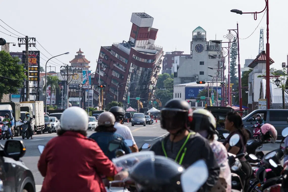 Local residents riding past a damaged building caused by the earthquake in Hualien on April 4, 2024. 