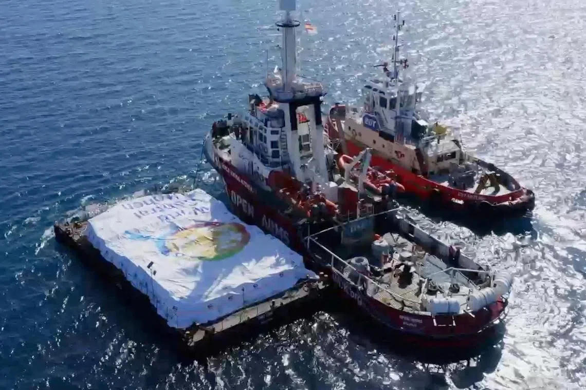 Aid ship sails, amidst a test to launch a new sea route from a port in Cyprus to deliver aid to residents of the Gaza Strip who are on the brink of famine, at sea, March 12, 2024, in this screen grab from a handout video.  World Central Kitchen/Handout via REUTERS