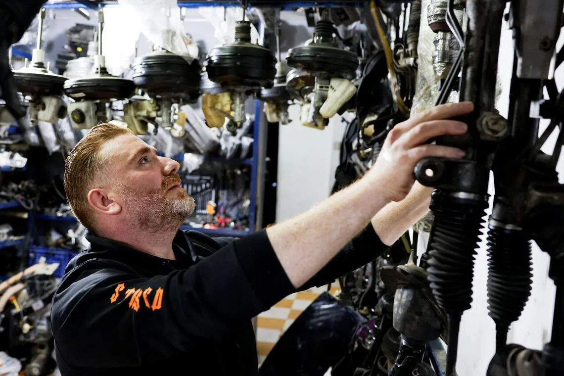 A Syrian, Ahmed al-Akhras, works at his car spare parts shop, in Cairo, Egypt December 12, 2024. REUTERS/Mohamed Abd El Ghany