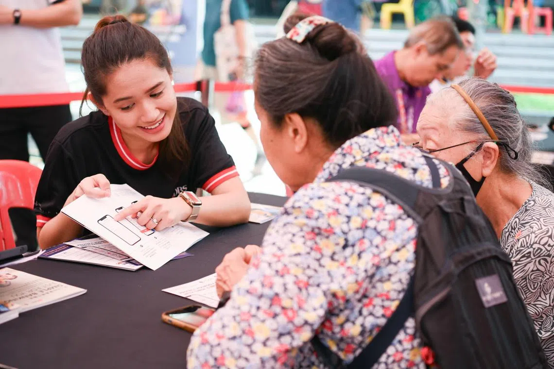 星展基金会和储蓄银行在红山景巴刹与熟食中心举办“街坊歌台欢乐”活动，银行义工与现场公众分享数码科技知识。（星展银行提供）