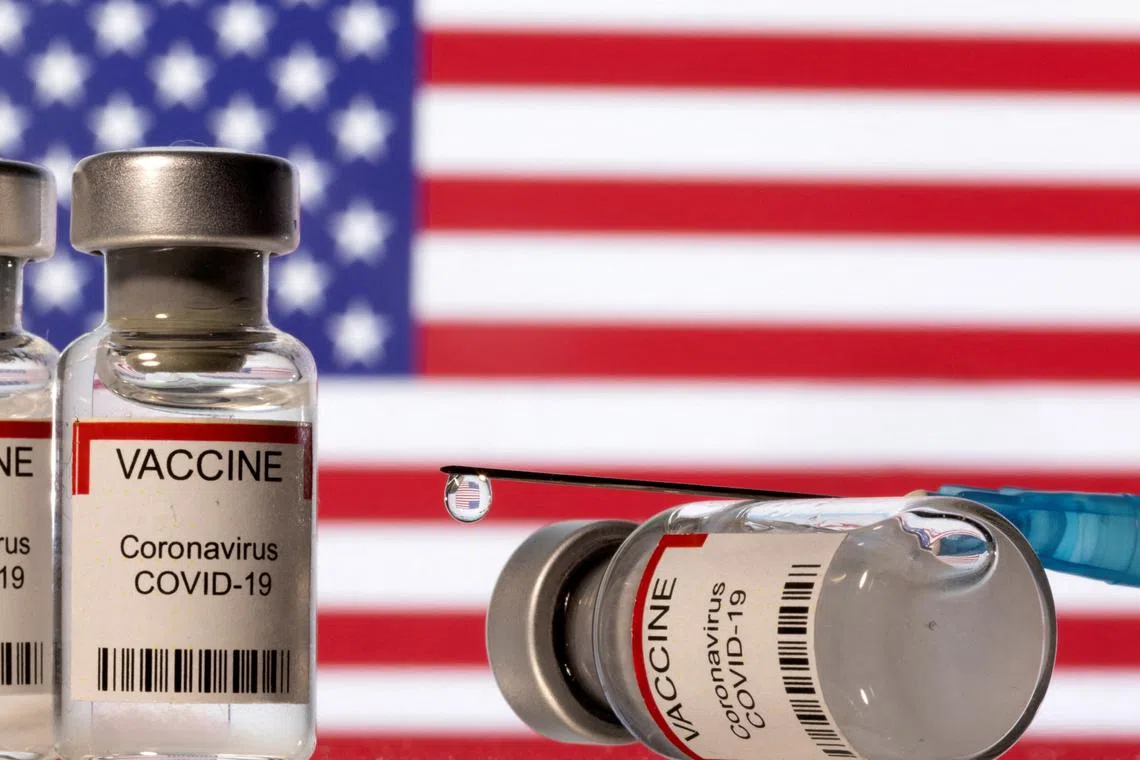 FILE PHOTO: Vials labelled \"VACCINE Coronavirus COVID-19\" and a syringe are seen in front of a displayed U.S. flag in this illustration taken December 11, 2021. REUTERS/Dado Ruvic/Illustration/File Photo