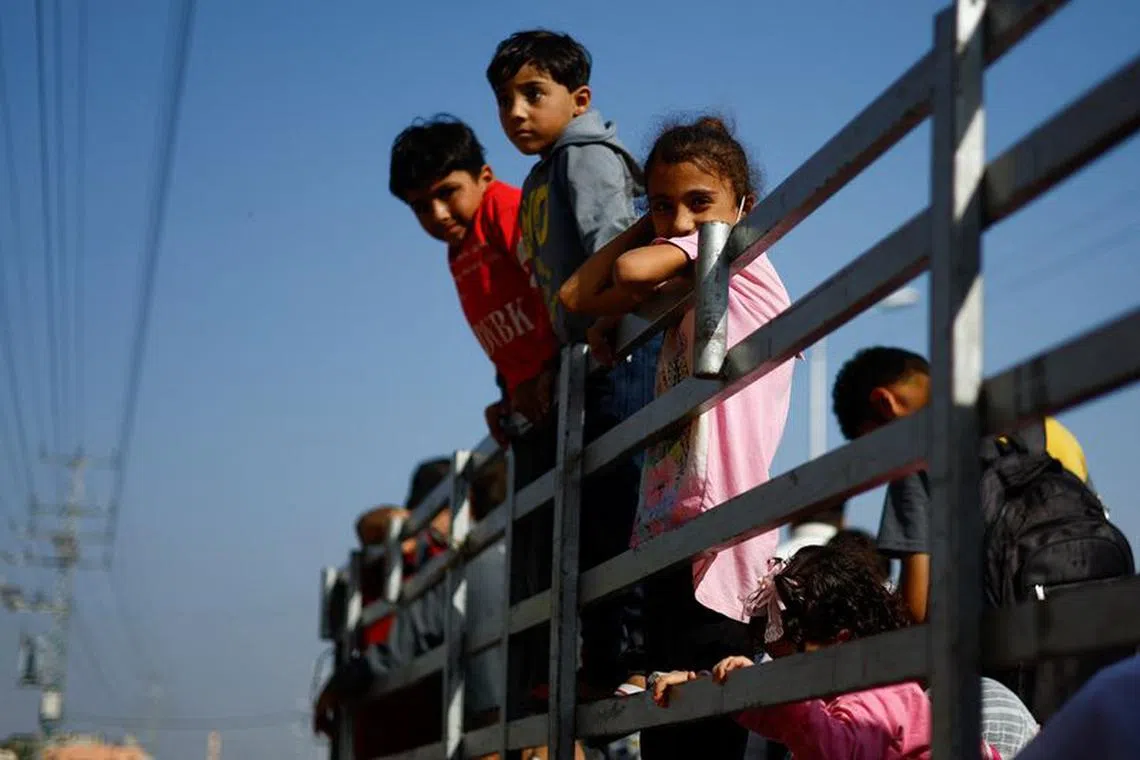 Children look on as Palestinians flee north Gaza, amid the ongoing conflict between Israel and Palestinian Islamist group Hamas, in the central Gaza Strip, November 9, 2023. REUTERS/Mohammed Salem