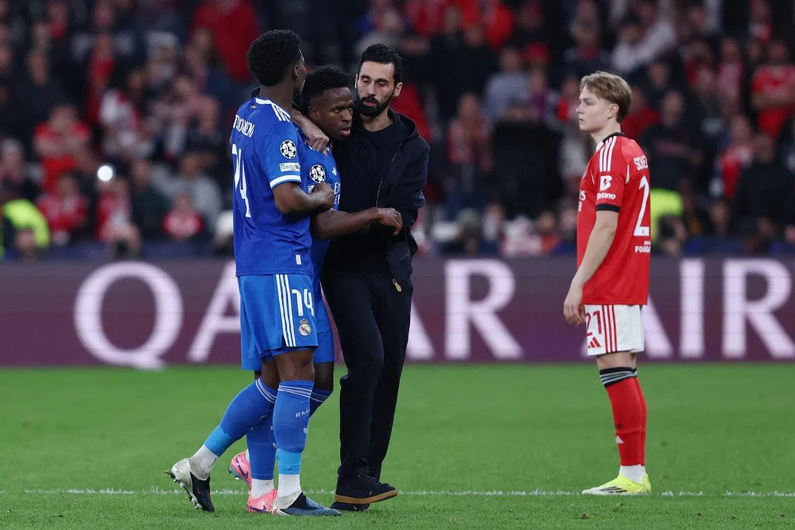 Soccer Football - UEFA Champions League - Play Off - First Leg - Benfica v Real Madrid - Estadio da Luz, Lisbon, Portugal - February 17, 2026 Real Madrid's Vinicius Junior with coach Alvaro Arbeloa and Aurelien Tchouameni as the match was stopped due to racist chants REUTERS/Rodrigo Antunes