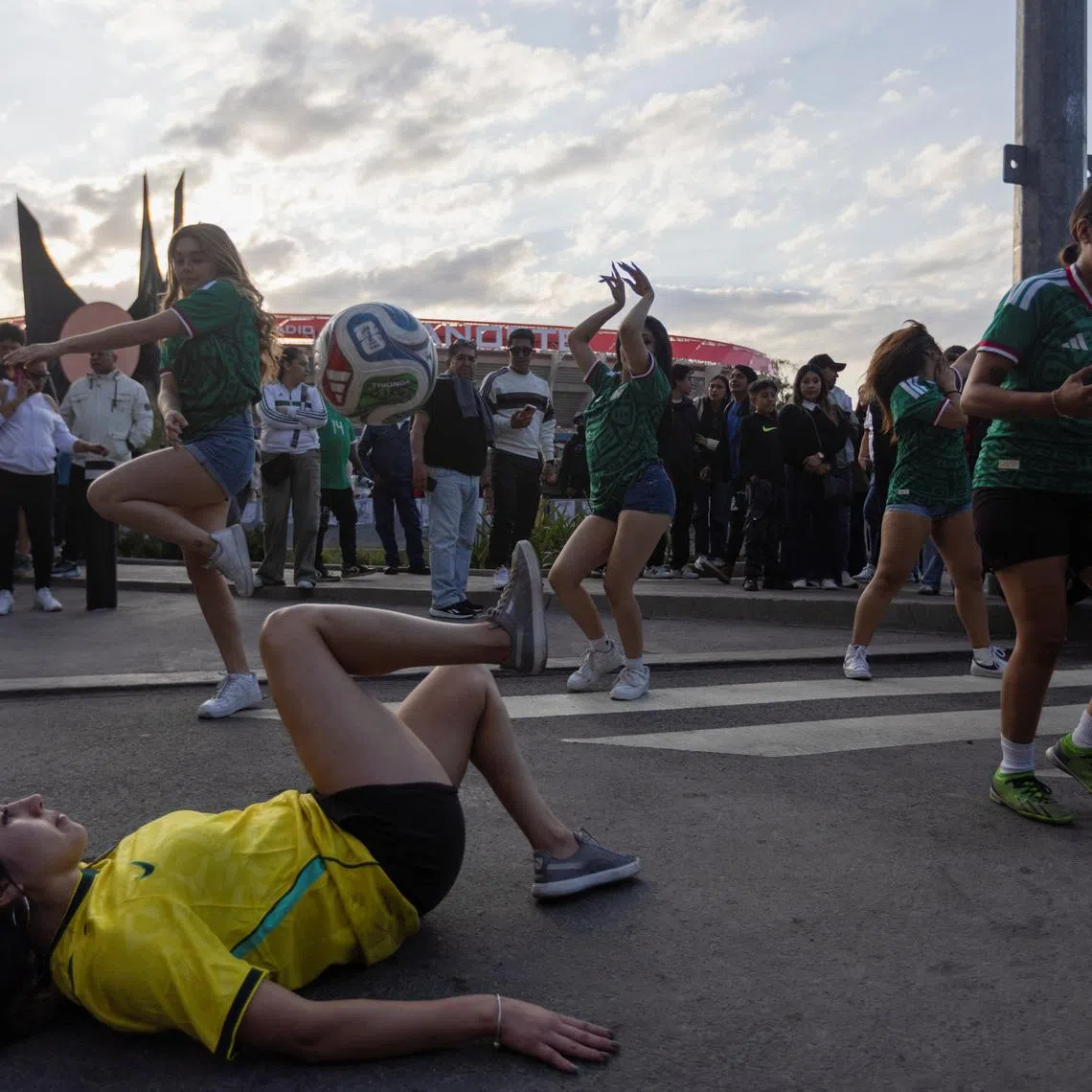 Female fans perform soccer tricks with balls outside Azteca Stadium, officially renamed Estadio Banorte, on the day of a friendly match between the national teams of Mexico and Portugal held to mark the stadium’s inauguration, as Mexico prepares for the 2026 FIFA World Cup co-hosted by the United States, Canada and Mexico, in Mexico City, Mexico, March 28, 2026. REUTERS/Quetzalli Nicte-Ha