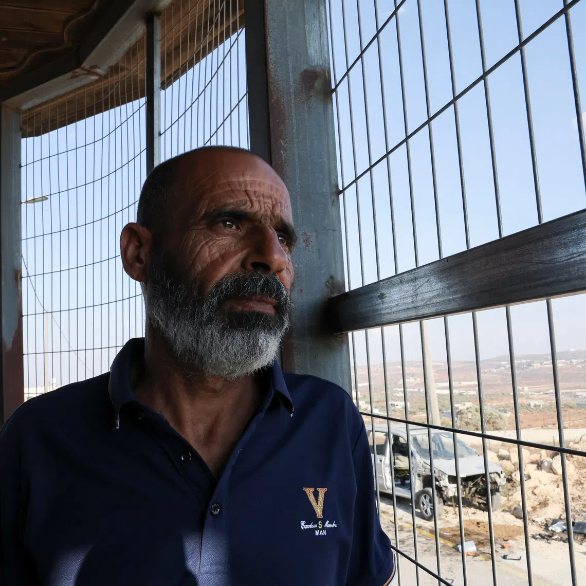 Marmar Ouda sits in front of metal bars installed to protect his family from militant settler attacks in the Palestinian village Qusra in the Israeli-occupied West Bank  August 14, 2026. REUTERS/Ammar Awad