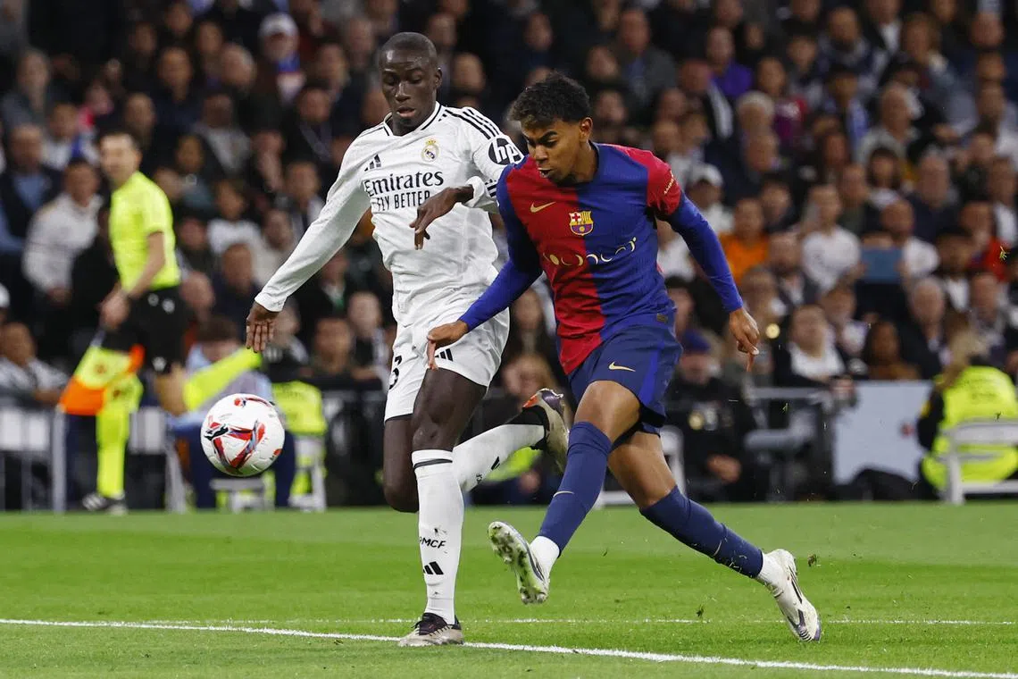 Soccer Football - LaLiga - Real Madrid v FC Barcelona - Santiago Bernabeu, Madrid, Spain - October 26, 2024 FC Barcelona's Lamine Yamal in action with Real Madrid's Ferland Mendy REUTERS/Susana Vera