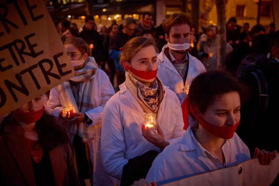 Protestors, with cloths covering their mouths, hold candles during a silent pro-life demonstration in Paris, on Feb 28 as the Senate started debates for inclusion of abortion in the Constitution.  