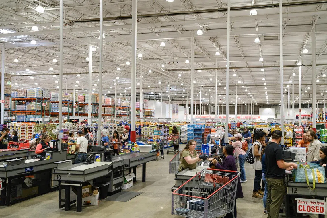 Shoppers check out at a Costco, the third-largest retailer in the world, behind only Amazon and Walmart, in Anchorage, Alaska, Aug. 16, 2024. More than 100 million people get their groceries (and TVs and gold bars and pet coffins) at Costco, but the retailer is not about what it seems. (Kerry Tasker/The New York Times)
