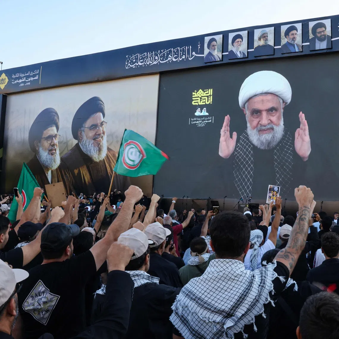 Hezbollah supporters shout slogans as they watch a televised speech by Hezbollah chief Naim Qassem during a ceremony held to mark the second anniversary of the killing of former leader Hassan Nasrallah in a strike by Israel, in Beirut’s southern suburbs.