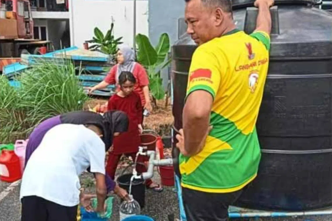 Residents filling up plastic containers with water from from state utility company Sada.