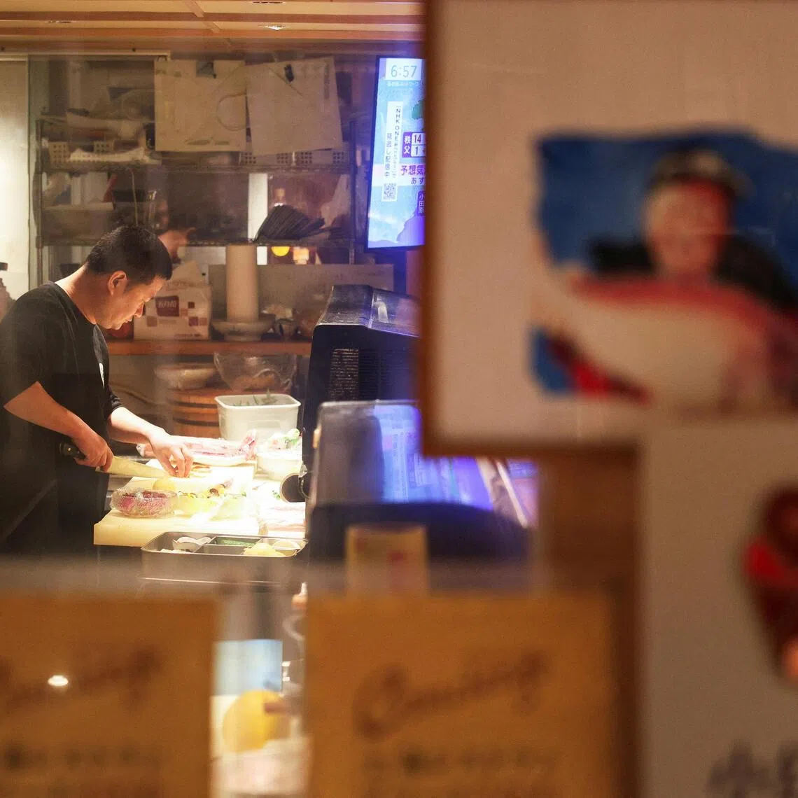 A chef of the Japanese restaurant Merase prepares a dish for customers, in Shanghai.