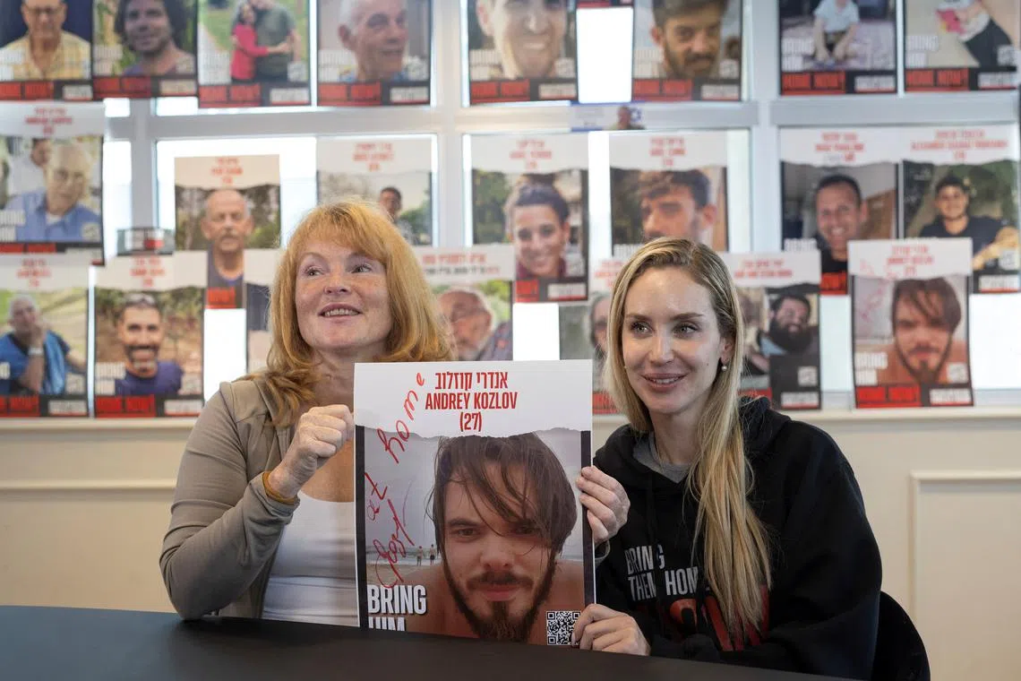 Evgeniia Kozlova, mother of Andrey Kozlov, and Jenifer Master, the girlfriend of Andrey Kozlov, who was taken hostage during the deadly October 7 attack by Hamas, hold a poster with Andrey's picture during an interview with Reuters after Israeli special forces rescued him from Gaza, in Tel Aviv, Israel, June 11, 2024. REUTERS/Marko Djurica