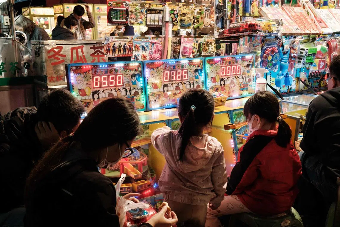 This photo taken on January 9, 2024 shows children playing at the Shanhua night market in Tainan. (Photo by Yasuyoshi CHIBA / AFP)