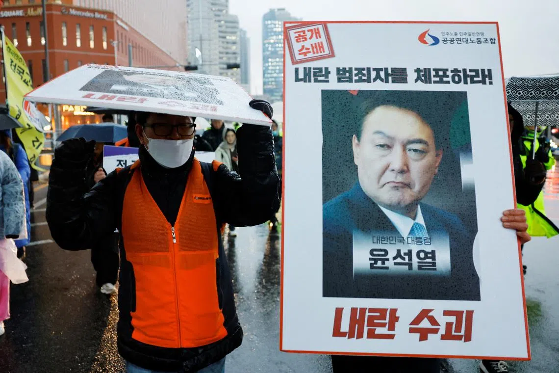 A protester holds a placard during a rally to call for South Korean President Yoon Suk Yeol's resignation in Seoul on Dec 5.