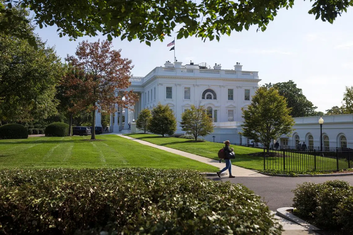 A person walks along the West Wing driveway at The White House in Washington, U.S, October 4, 2024. REUTERS/Tom Brenner/File Photo