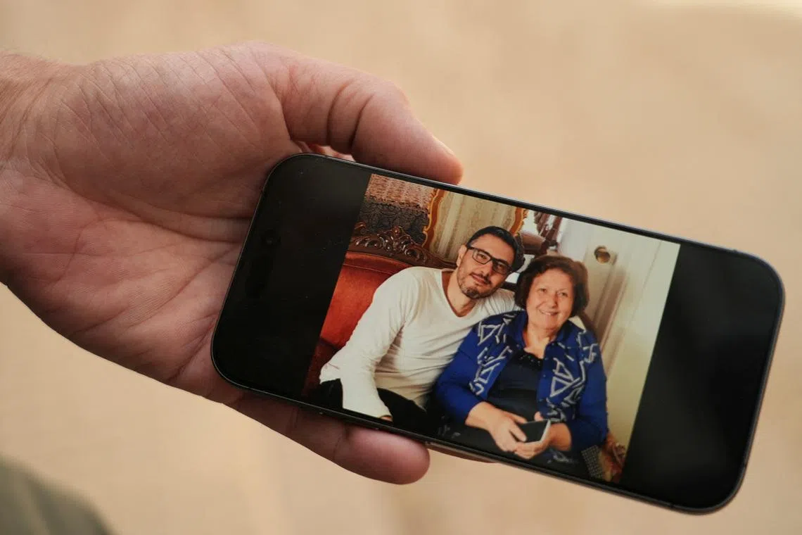 Mr Wael Sabbagh displays on a mobile phone a picture of his mother Afaf Sidaoui and his brother Hassan, who were killed in an Israeli strike on April 8.