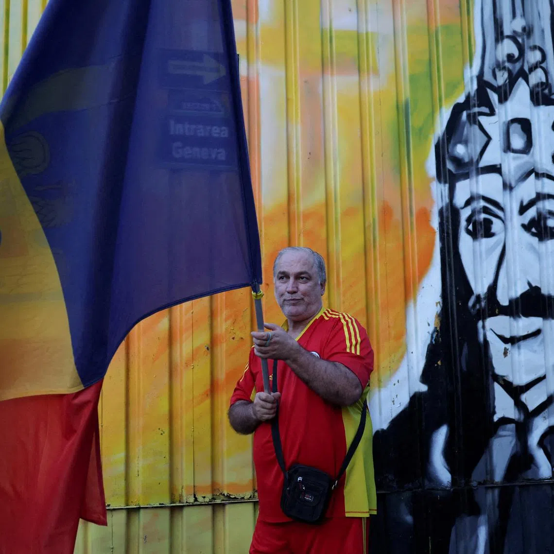 A person holds a flag as supporters wait for poll results, on the day of Romanian presidential election, outside the Alliance for the Union of Romanians (AUR) headquarters in Bucharest, Romania, May 4, 2025. REUTERS/Louisa Gouliamaki      TPX IMAGES OF THE DAY